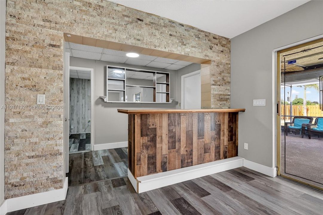 BEHIND THE BUILT IN BAR AND DOOR LEADING TO THE POOL