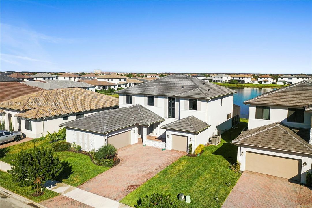 Aerial view of the subject home centered in Maple Ridge with lake behind