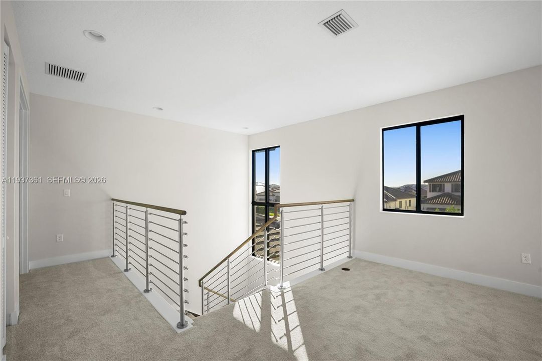 Carpeted loft or flex space with recessed lighting