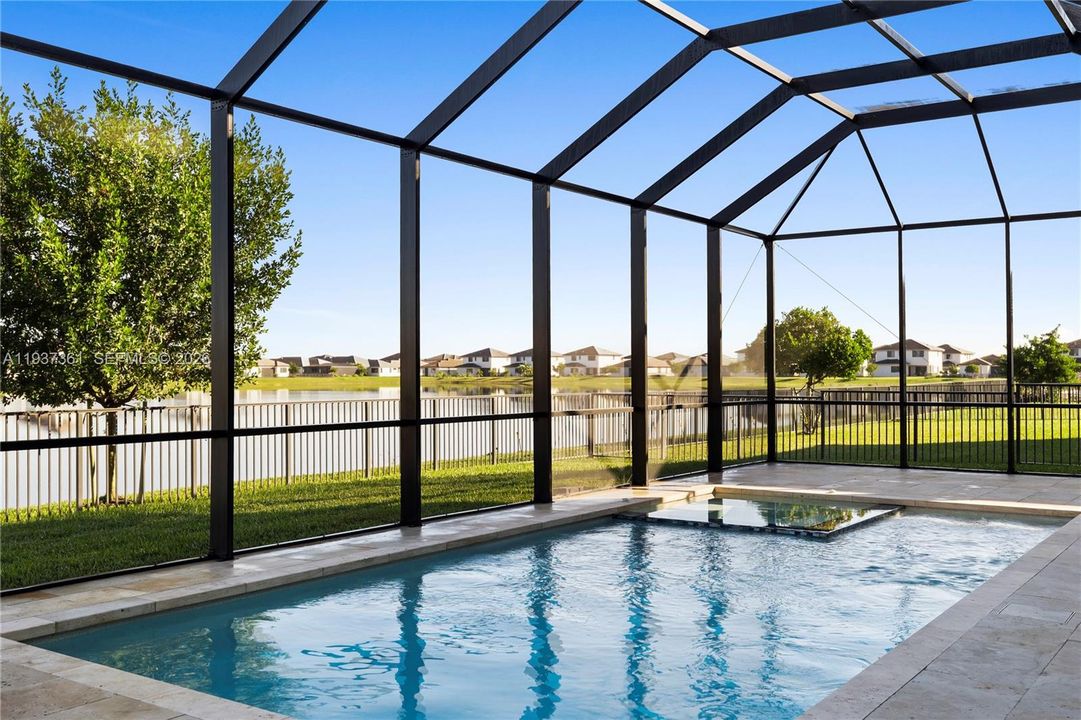 Screened lanai with heated saltwater pool and spa overlooking the lake