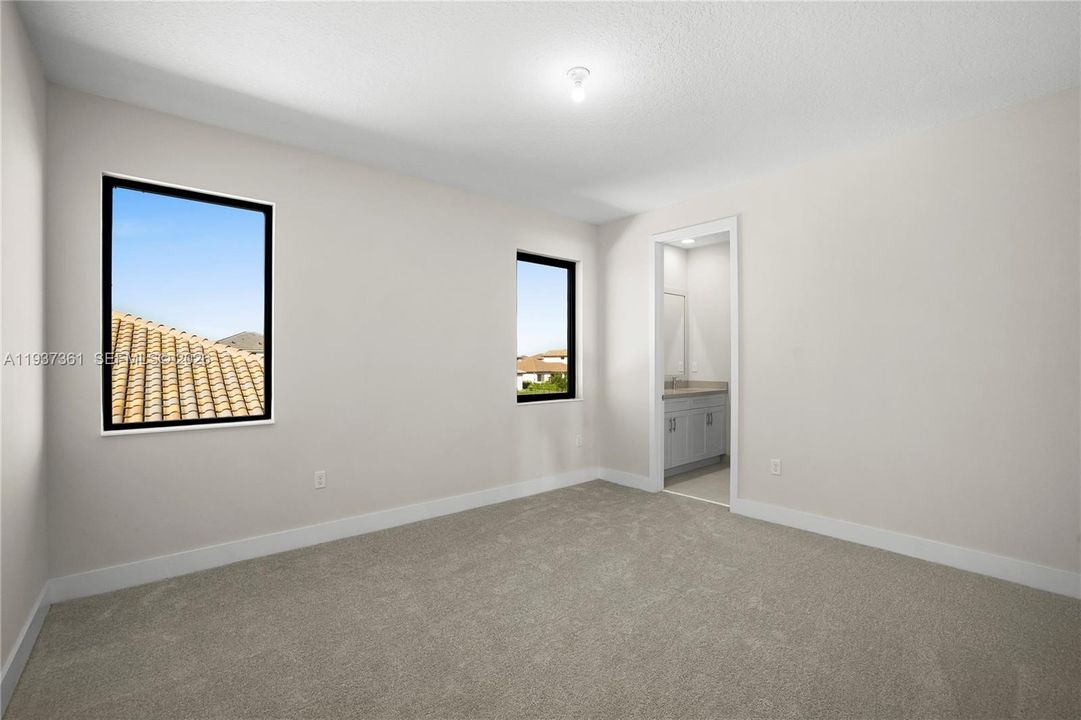Jack-and-Jill bedroom with recessed lighting and neutral finishes