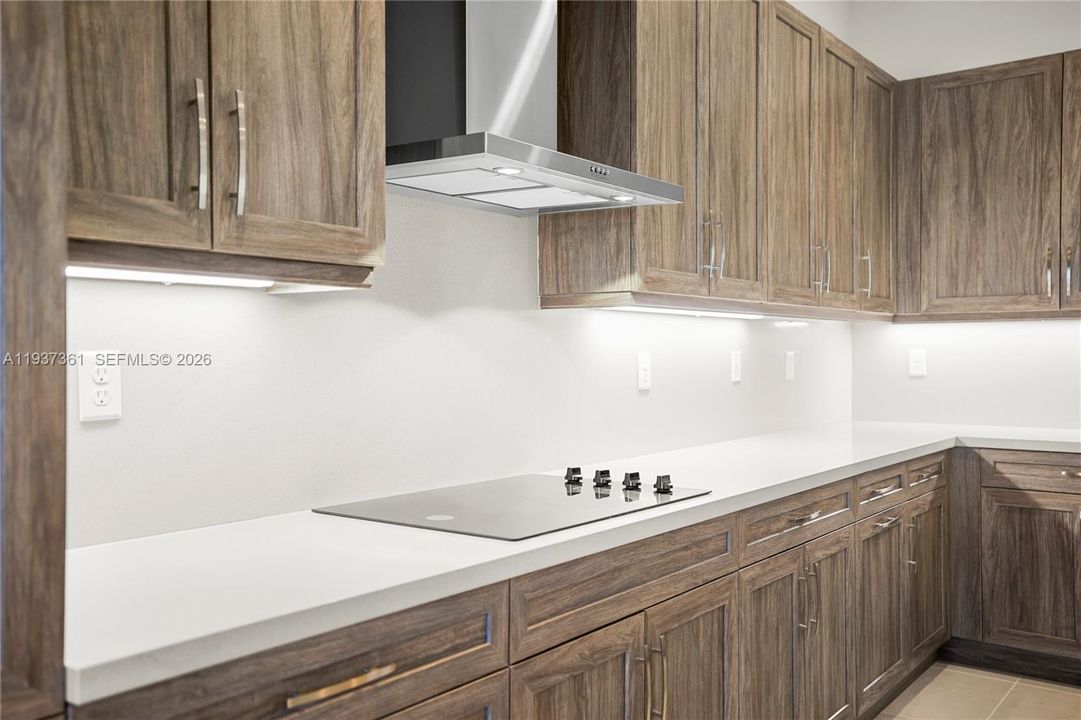 Kitchen detail with wall-mounted hood and quartz slab backsplash