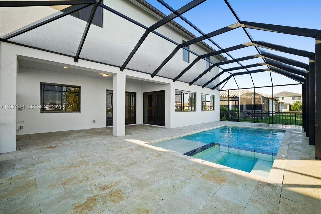 Lakefront heated saltwater pool and spa with travertine decking