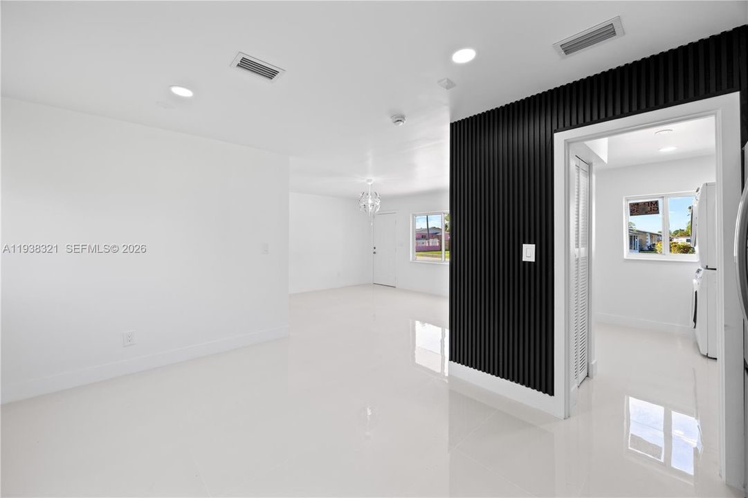 View of the main entrance door and living area from the kitchen.