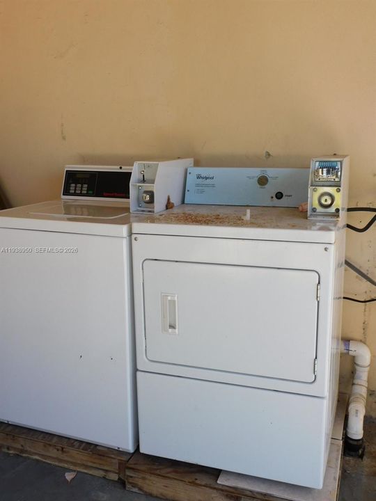 Coined operated washer and dryer at rear covered patio.