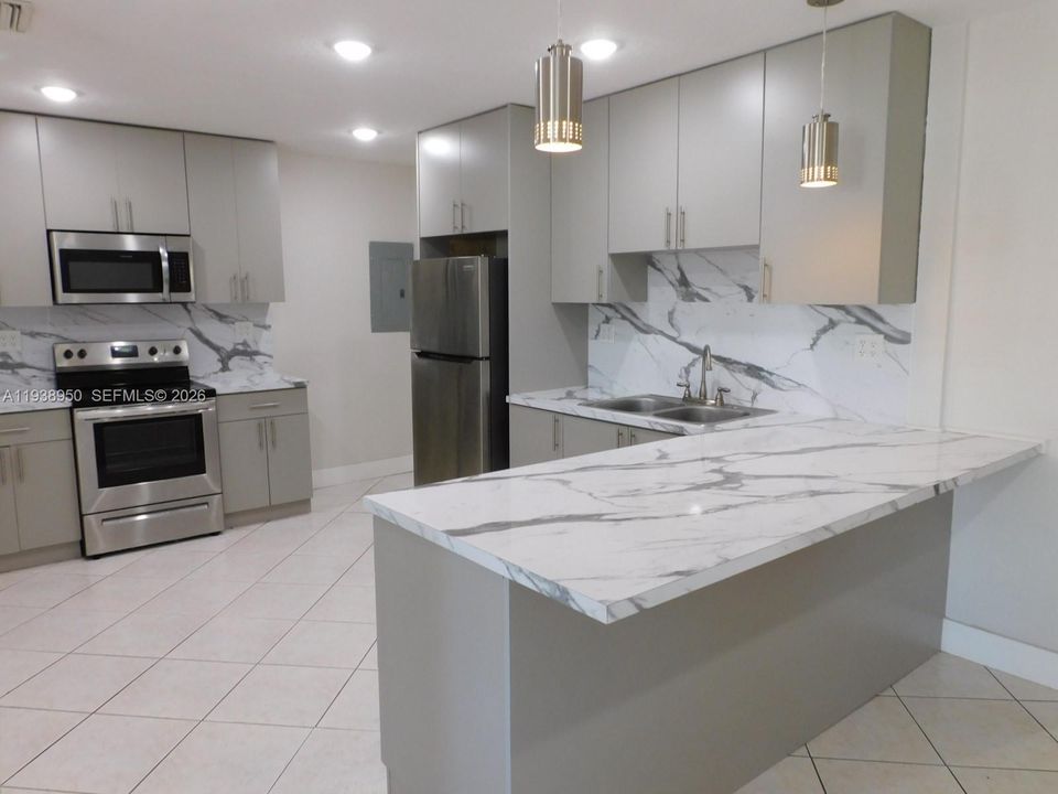 Remodeled Kitchen with SS Appliances and Quartz Countertops/Backsplash.  Breakfast snack counter.