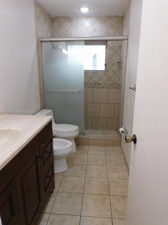 Updated bathroom with walk-in shower with glass doors.