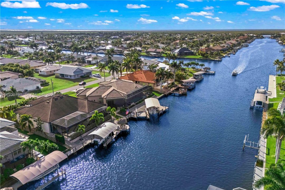 The BEST of waterfront living with an expanded outdoor area, boatlift, expansive pavered backyard/boat deck and a canopied lift and boat. Tiki hut is the PERFECT place to kick back and watch both the sunrise and sunset!