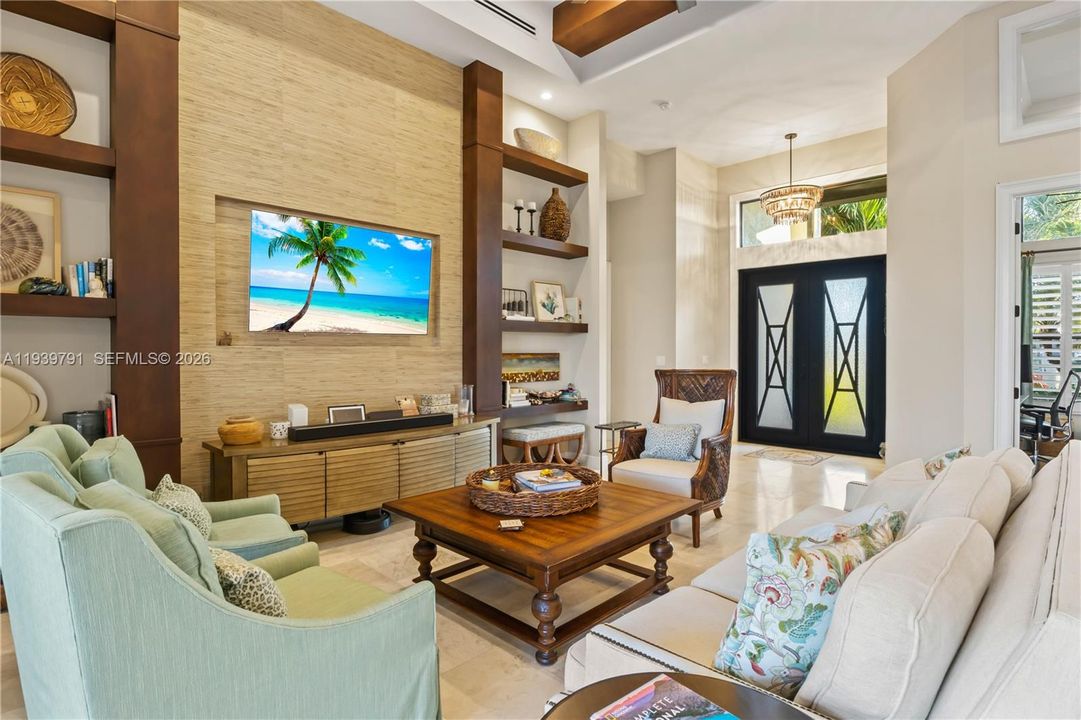 Custom living area, where the TV wall panel stands as a sophisticated focal point in a tastefully designed space. Tall ceilings, linear ac vents - this home is customized and timeless!