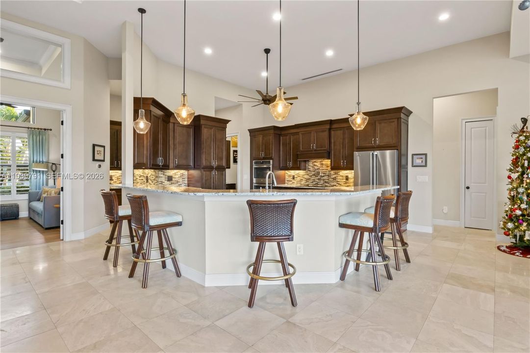 From the lanai, the kitchen unfolds in full view, blending functionality with elegance and maintaining a perfect line of sight to the living and dining areas.