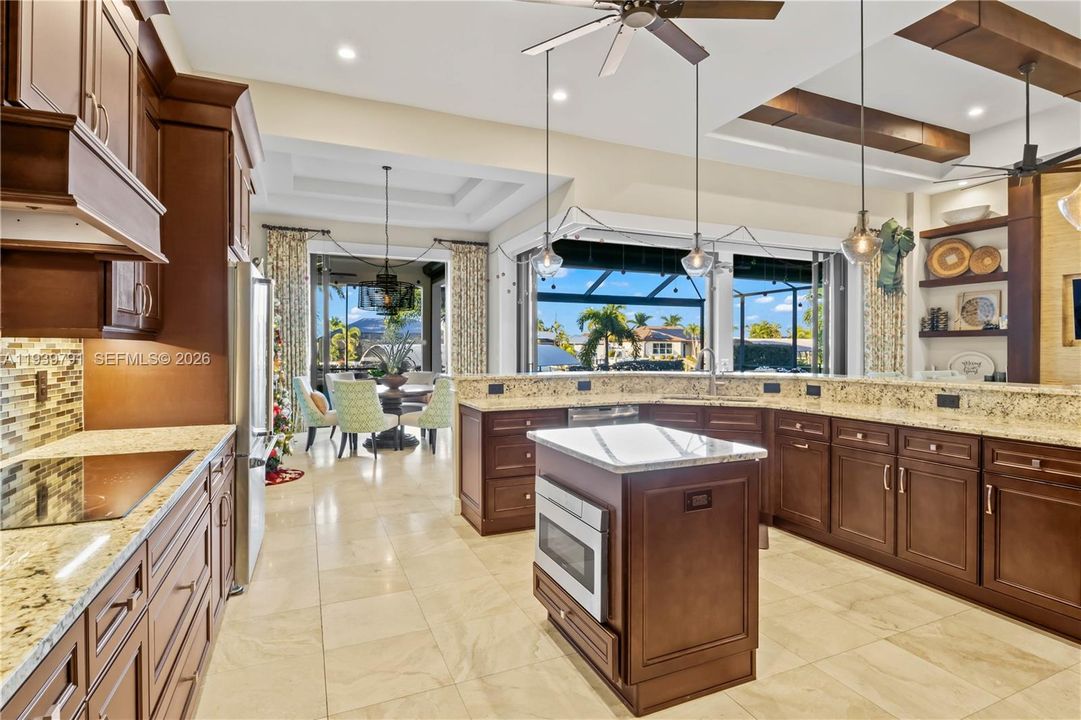 Gourmet kitchen with granite countertops, custom wood cabinetry, and a large breakfast bar, designed for both style and functionality.
