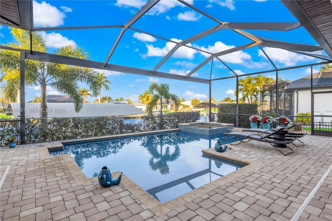 Heated pool and spa oasis with ambient lighting, perfect for unwinding while enjoying serene canal views or stunning sunsets.