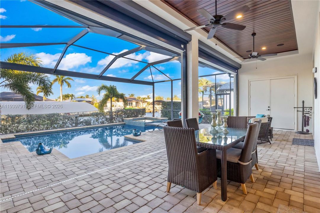 Private backyard oasis featuring spacious seating areas, pool, and direct canal access.