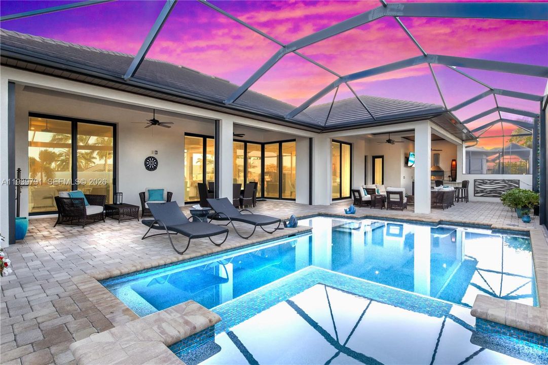 Inviting pool and spa retreat with a sun deck and lounge areas, offering a seamless blend of relaxation and luxury waterfront living.