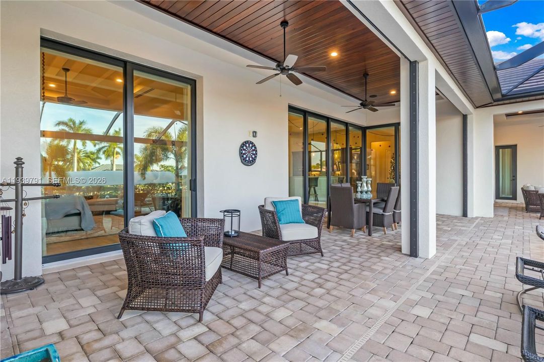 Entertainer’s dream with custom outdoor kitchen, seating, and poolside convenience.