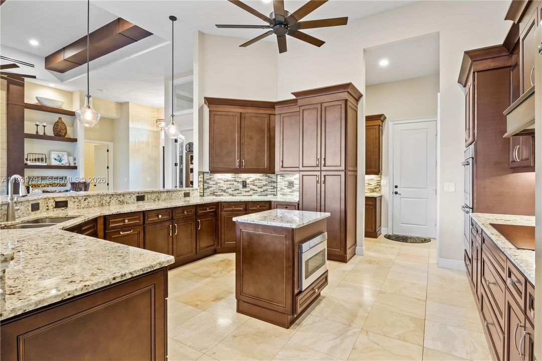 Chef’s dream kitchen boasting state-of-the-art appliances, abundant storage, and sleek travertine flooring.