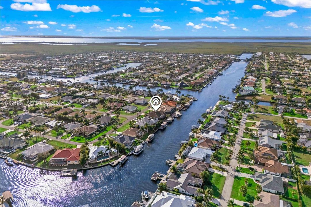 Drone shot featuring the entire estate and adjacent waterway, illustrating the home’s luxury design and idyllic waterfront location.