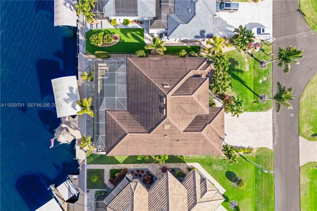Aerial view highlighting the roof design and property layout, providing a comprehensive perspective of the home from above.