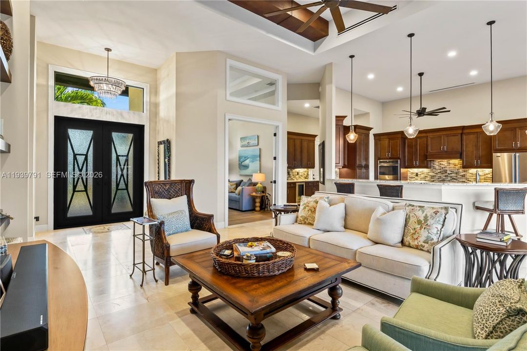 Inviting view from the poolside lanai toward the front entrance. Custom beams, transom window for natural light - everywhere you look there are tasteful and subtle touches which make this home stand out amongst the rest!