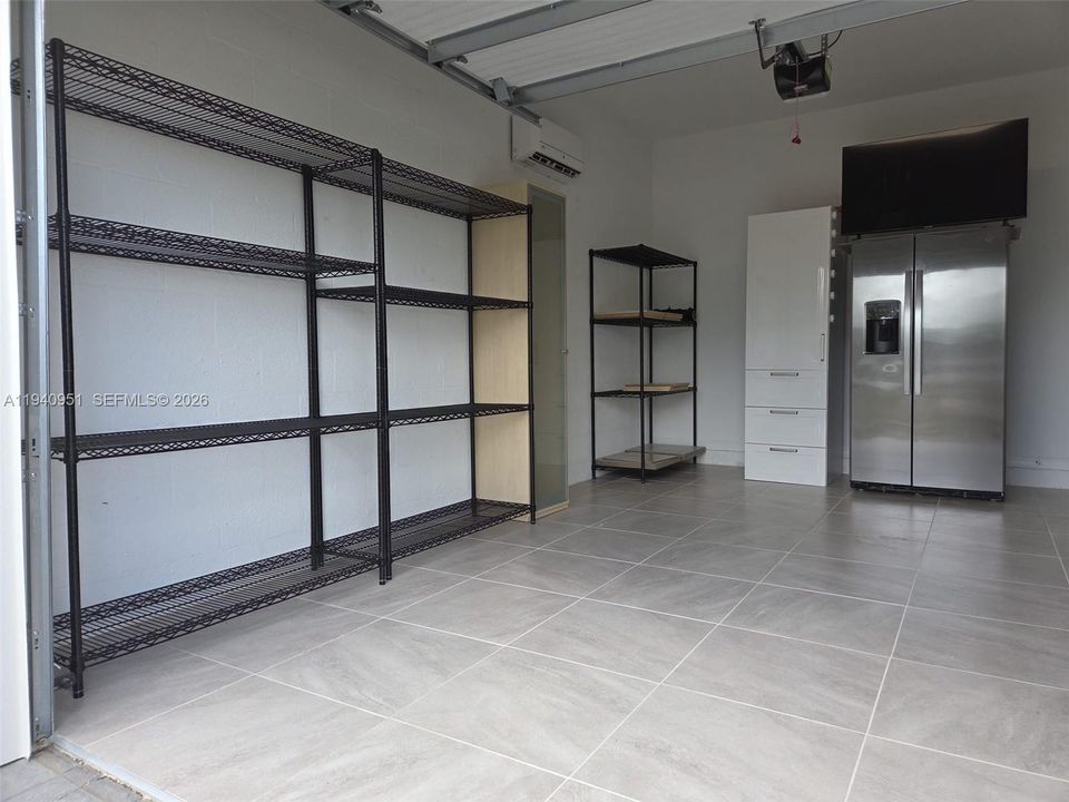 1 car Garage upgraded with tile floor, mini split and insulated garage door with stainless steel fridge, perfect for gym, workshop, craft room, etc