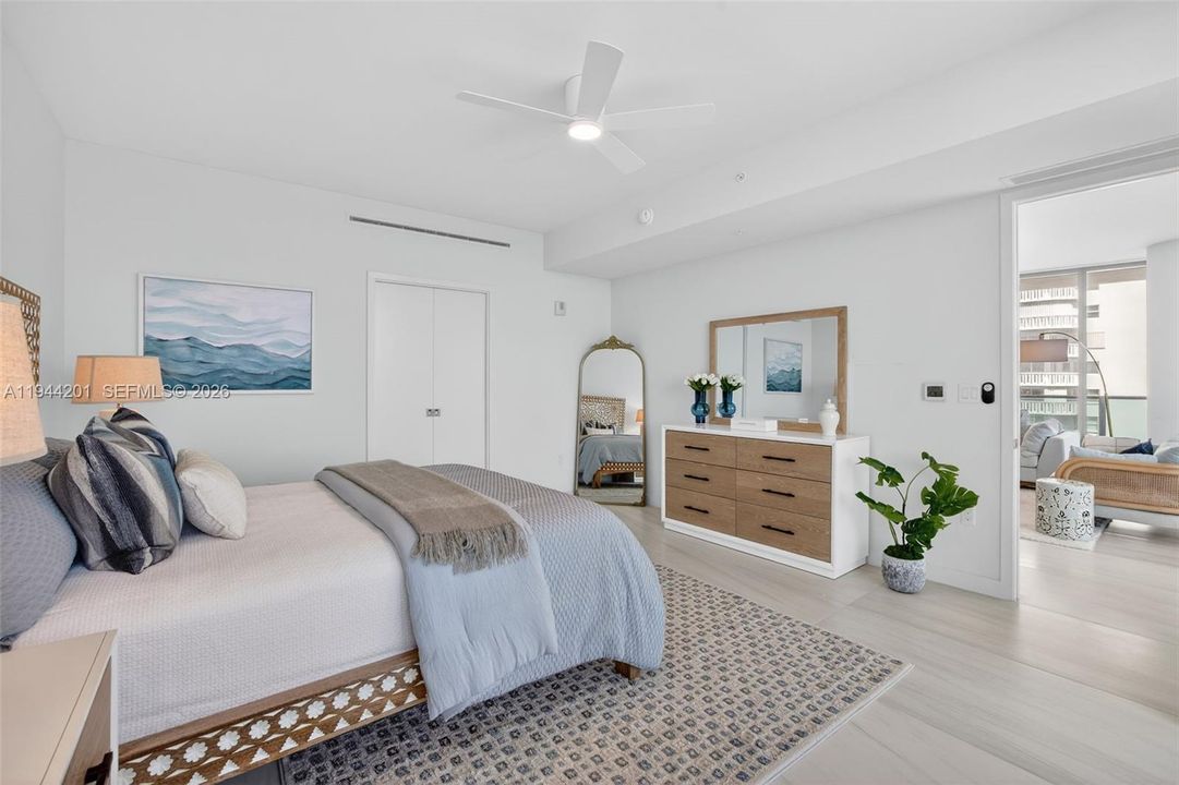 Spacious primary suite with floor to ceiling glass, terrace access, two walk in closets, and spa inspired bath.