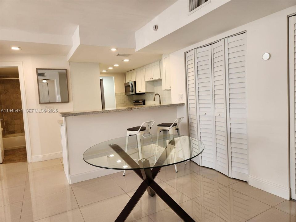 This view shows dining area with kitchen bar and additional closet for either storage space or convert to a wine/coffee bar.