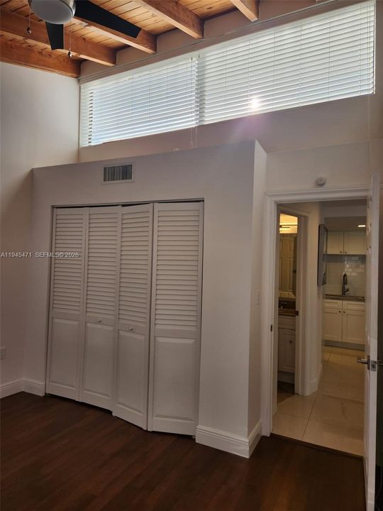 Second bedroom shows clerestory window and high ceilings.