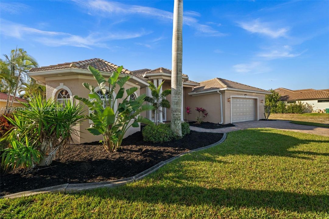 Lush tropical landscaping surrounds the home