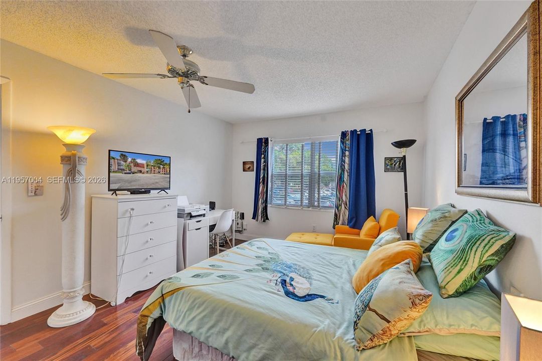 The spacious master bedroom is filled with natural light, creating a bright and airy atmosphere