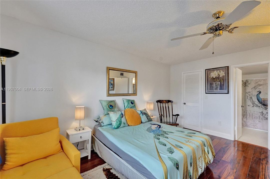 The spacious master bedroom is filled with natural light, creating a bright and airy atmosphere