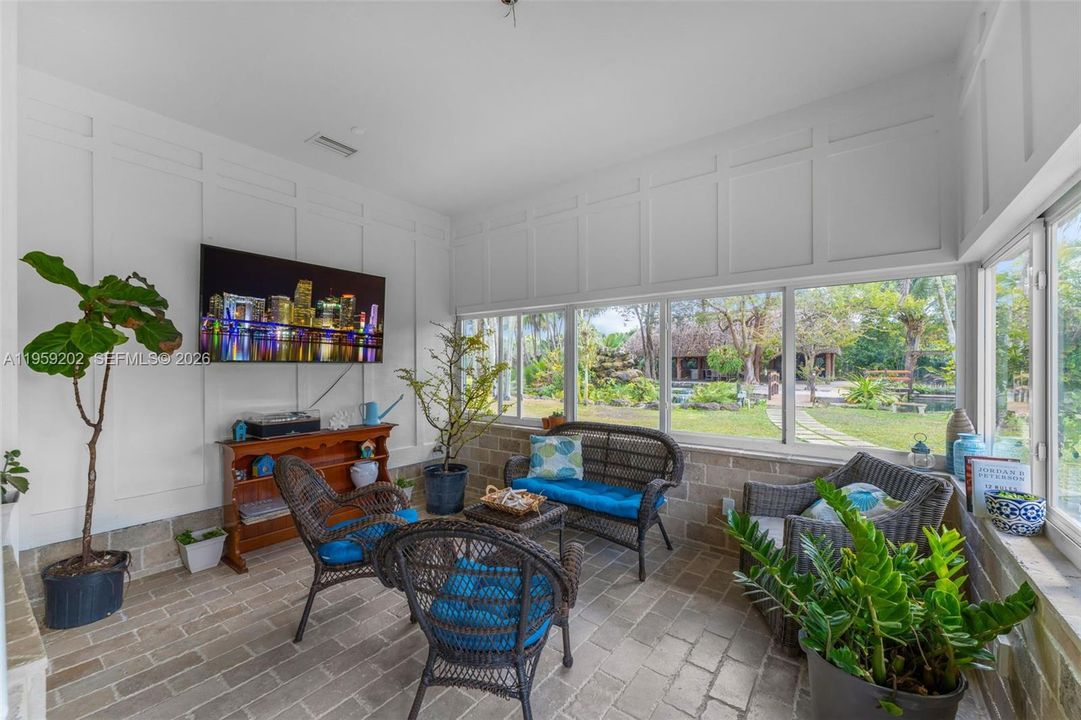 ENCLOSED PATIO W/ AC COULD BE A FAMILY ROOM WRAPPED WITH IMPACT WINDOWS OVERLOOKING THE GROUNDS
