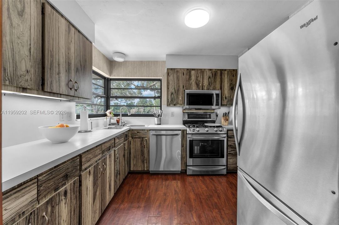 COUNTRY GALLEY KITCHEN W/  CORNER WINDOWS, CHEFS GAS STOVE, LARGE REFRIGERATOR & LOTS OF COUNTER SPACE.