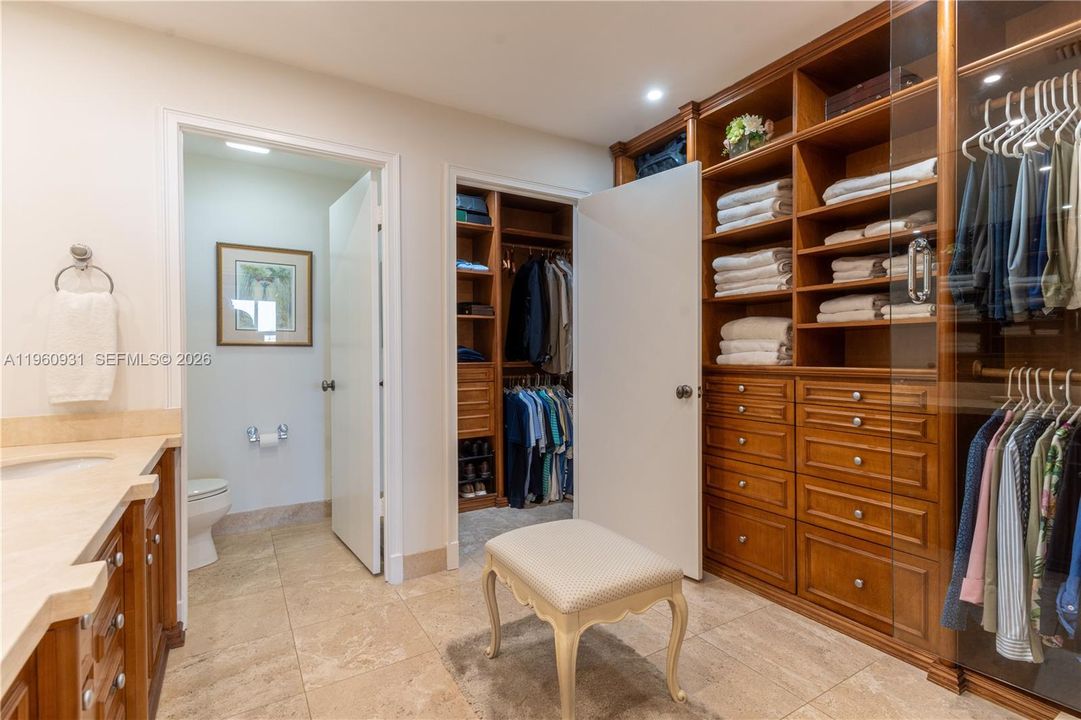 The walk-in closet and wall cabinet are equipped with built-in shelving and drawers.