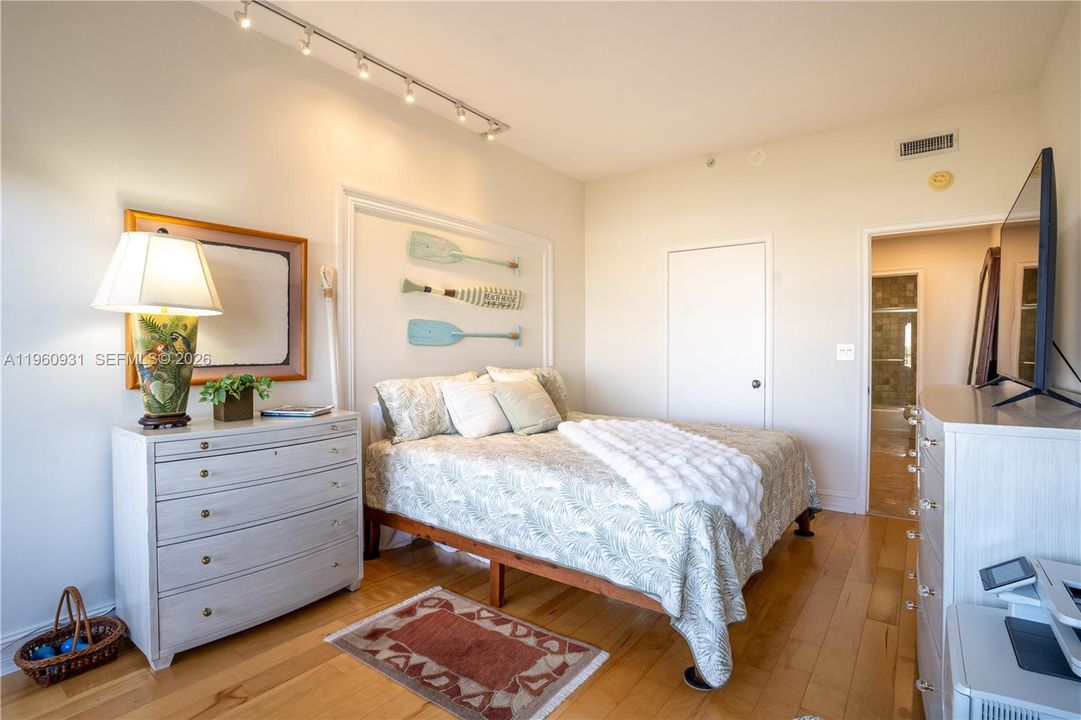 The bedroom is well lit by natural light and has ample space to accommodate an additional bed or sitting area.