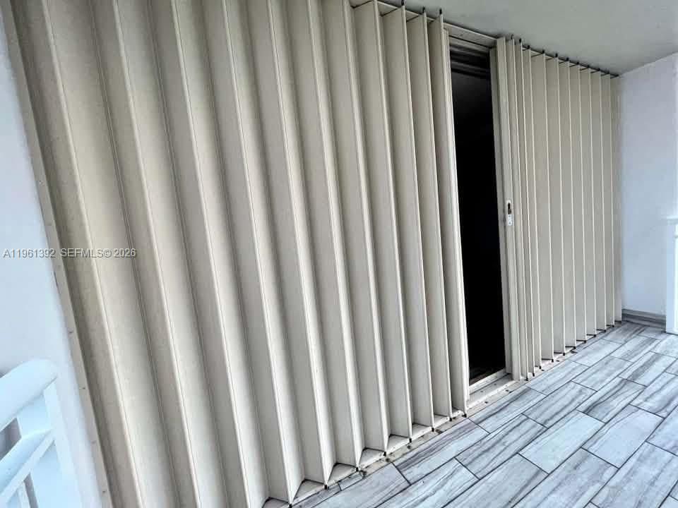 Accordion-style exterior storm shutters and wood-finish tile flooring