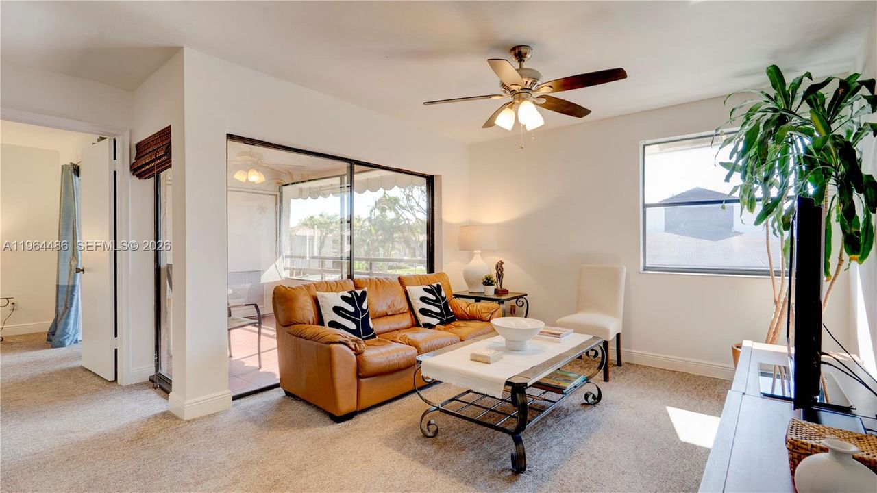 living room leading to primary bedroom with view of screened porch