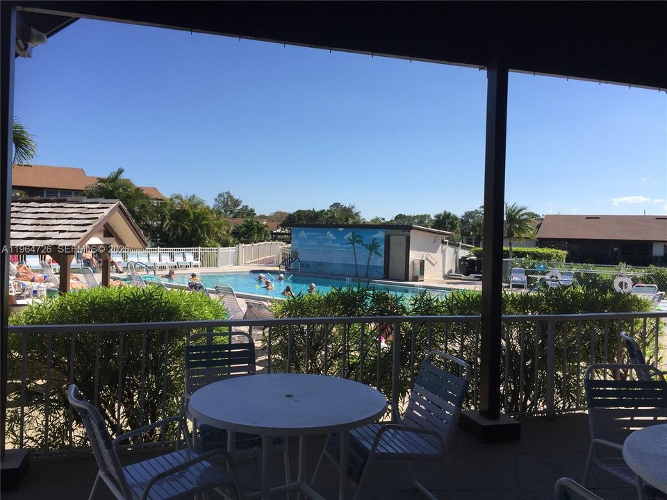 SHADED AREA WITH TABLES OVER-LOOKING THE POOL.