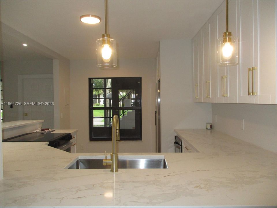 VIEW FROM DINING AREA INTO THE KITCHEN WITH WHITE QUARTZ COUTERTOPS