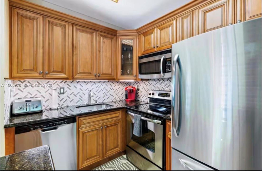 FULLY RENOVATED KITCHEN WITH STONE COUNTERTOP AND STAINLESS STEEL APPLIANCES
