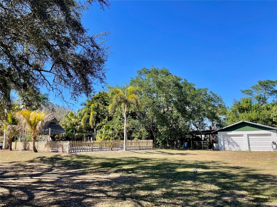 VIEW OF FENCED SALT WATER POOL, GARAGE AND POLE BARN