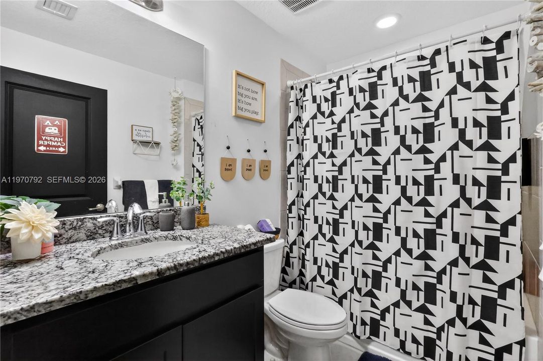 Guest bathroom has a bath and shower.