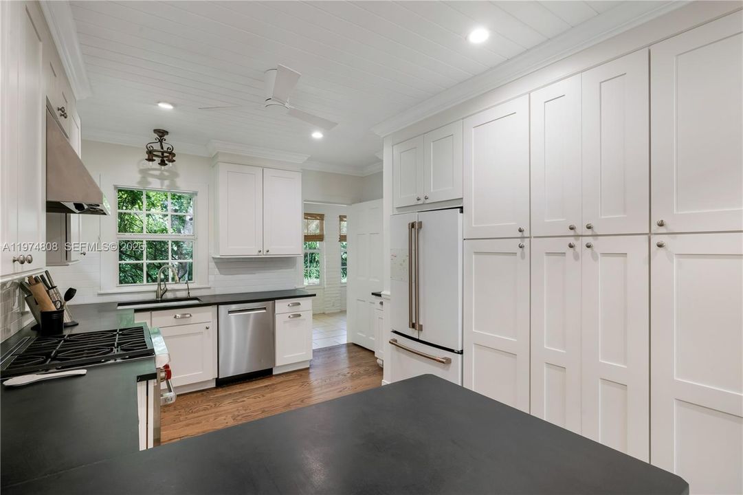 Kitchen has lots of cabinet closets with access to the dining area.
