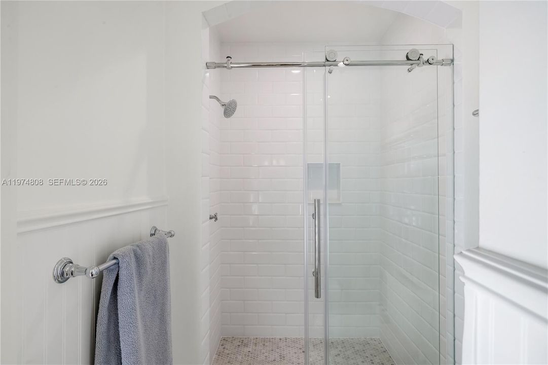 Private shower area in the primary bathroom. This spacious area offers a luxurious and comfortable showering experience, featuring modern fixtures and finishes for ultimate relaxation.
