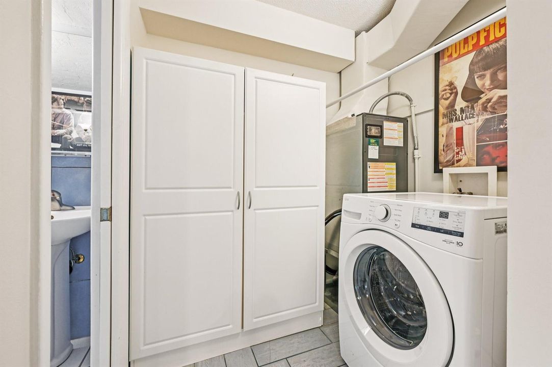 Laundry room with washer and storage