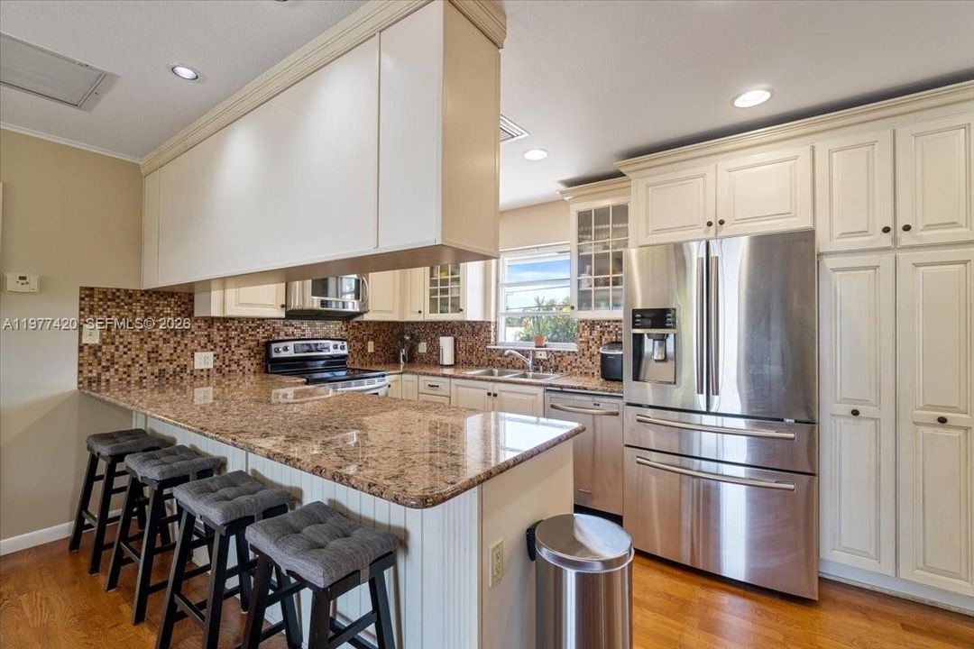 Spacious kitchen with built-in cabinetry and open flow into the dining area, designed for comfortable island living.