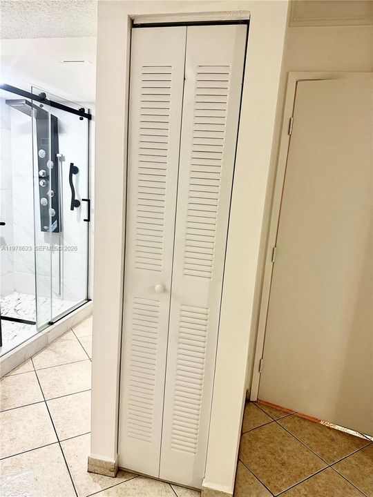 ACCORDION DOOR TO SHELVED CLOSET MAY BE USED FOR LINENS/TOWELS etc. (DOOR TO PRIMARY BEDROOM ENTRANCE, PICTURED TO RIGHT)