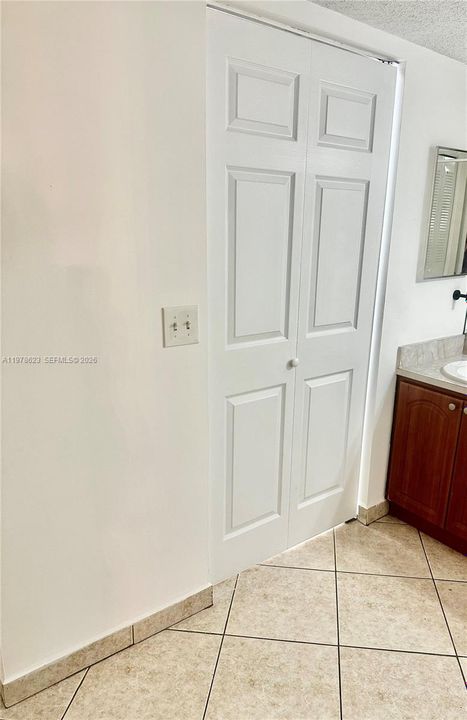 ACCORDION DOOR LEADING TO SPACIOUS WALK IN CLOSET