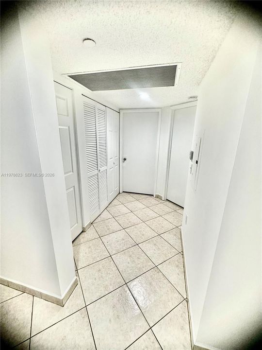 HALL LEADING OFF FROM ENTRANCE HALL TO HALL OF APPLIANCE CLOSETS (WATER HEATER-A/C & W/D), MAIN BATHROOM, 1ST BEDROOM