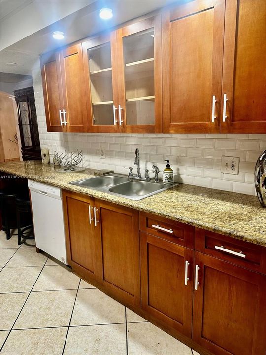 SUBWAY TILE BACKSPLASH-GRANITE COUNTERTOP WITH AN END SNACK/EAT IN BAR AREA THAT FITS 2 STOOLS  (FAUCET & SPRAYER PICTURED HERE WAS REPLACED-SEE NEXT PHOTO)