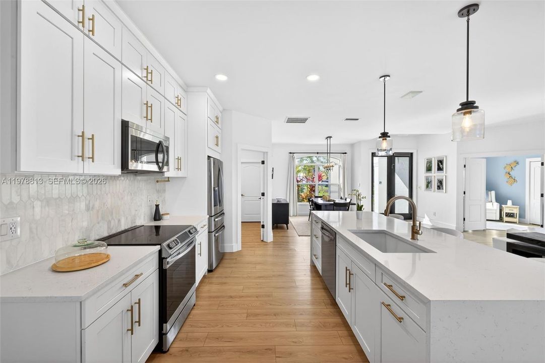 Kitchen featuring gorgeous backsplash, & 9' island w/quartz waterfall countertop